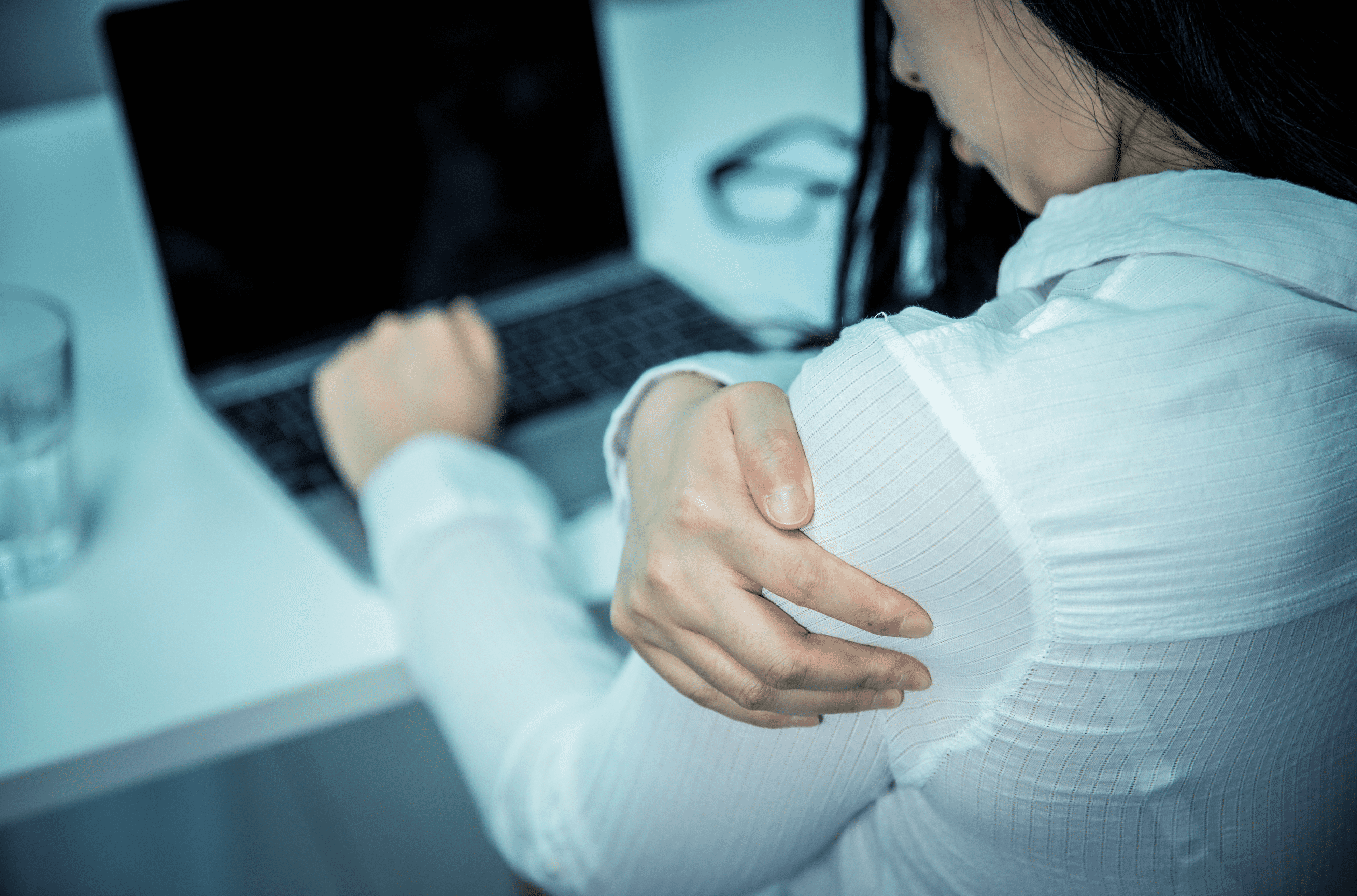 Woman With Shoulder Pain Working On Laptop